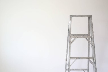 Yeni evin boş odasındaki alüminyum merdiven. Teknisyenlerin daha yüksek işlerde kullanması için. Kopyalama alanı olan resim