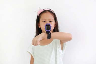 Beyaz arka planda akıllı saat kamerasını kullanan Asyalı küçük kızın portresi. Akıllı olmaya odaklan. Eline dikkat et..