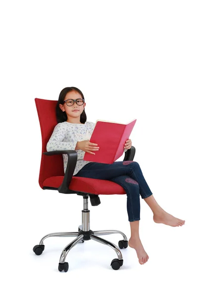 亚洲女孩坐在红色的面料椅子上看书 看着被白色背景隔离的相机 图像全长与裁剪路径 — 图库照片