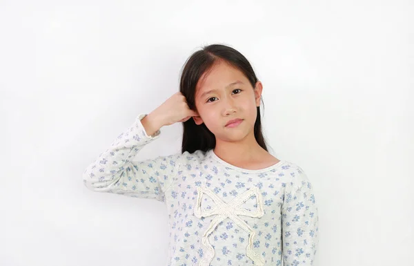 アジアの女の子の子供は小さな指で一つの耳をカバーしないように聞くと白の背景に隔離されたカメラを見て — ストック写真