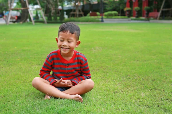 Lächelndes Asiatisches Knabenkind Übt Achtsamkeitsmeditation Sitzend Auf Rasen Garten — Stockfoto