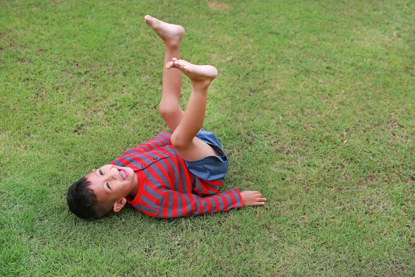 Adorable Asian Little Boy Lying Grass Lift His Legs Garden — Stock Photo, Image