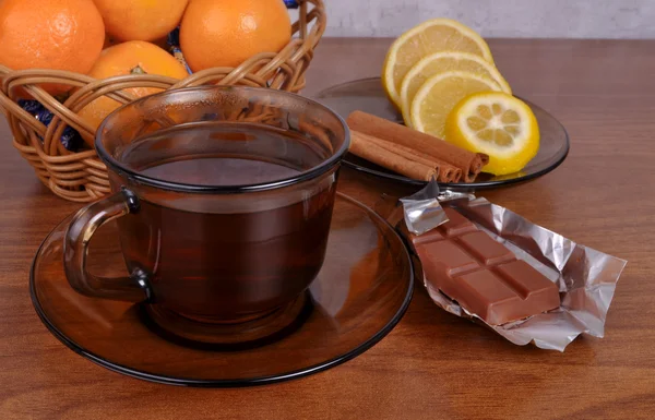 Bodegón con una taza de té, chocolate y limón — Foto de Stock