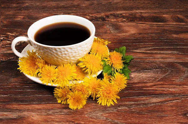Ahşap zemin üzerine çiçekli kahve kupa — Stok fotoğraf