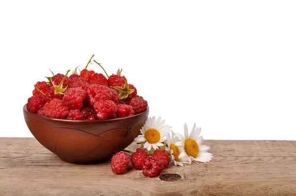 Ripe raspberries in a bowl on a wooden table on a white backgrou — Stock Photo, Image