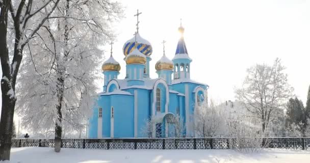 Χωριό Krasnoe, περιφέρεια Gomel, Λευκορωσία. Παλιά Ορθόδοξη Εκκλησία της Κοιμήσεως της Θεοτόκου σε ηλιόλουστη χειμωνιάτικη χιονισμένη ημέρα. Διάσημο ορόσημο κάτω από χιονοπτώσεις στο πάρκο Snowy — Αρχείο Βίντεο