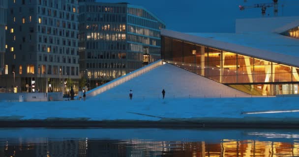 Oslo, Noruega Vista noturna da iluminada Ópera Nacional Norueguesa e Ballet House entre os edifícios contemporâneos de alta ascensão. — Vídeo de Stock