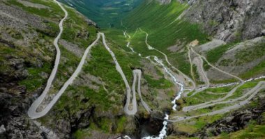 Trol stijeni, Endülüs, Norveç. Arabalar Serpentine Mountain Road Trollstigen 'e gidiyor. Ünlü Norveç Tarihi Yeri ve Popüler Varış Yeri. Norveç İlçe Yolu 63. Yaz Günü. Eğik Manzara. 4K
