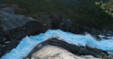 Kinsarvik, Hordaland, Norveç. Şelale Nykkjesfossen, Hardangervidda Dağı Platosu 'nda. Bahar Güneşi Günü. Nehir suyunun yakın görüntüsü. Ünlü Norveç Tarihi Yeri ve Popüler İstikamet
