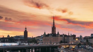 Stockholm, İsveç. Stockholm Skyline 'ın yaz akşamındaki manzarası. Sunset Lights 'daki ünlü Popüler Hedef Yer. Riddarholm Kilisesi, Metro Demiryolu. Günden Geceye Geçiş Zamanı Hızı. 4K