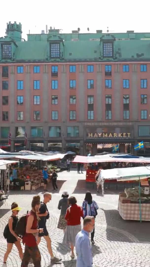 瑞典斯德哥尔摩- 2019年6月28日：人们参观当地的Hay Market Hotorget 。垂直、垂直射击、垂直录像 — 图库视频影像
