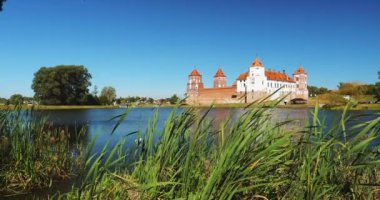 4K Mir, Belarus, Mir Kalesi Kompleksi ve Lake Landscape. Feodalizm Mimari Topluluğu, Antik Kültür Anıtı, UNESCO Dünya Mirası Alanı. Yazın ünlü simgesi Mavi Gök Altında Güneşli Gün