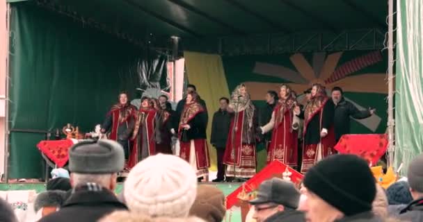Gomel, Vitryssland - 18 februari 2018: Ung kvinna flicka klä sig i nationella folk huvudduk, viftar med handen till kameran under firandet National Traditional Holiday Maslenitsa. Vinterlov — Stockvideo