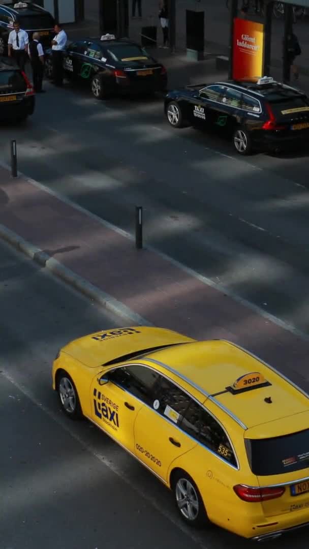 ストックホルム、スウェーデン- 6月28 、 2019:黄色のタクシー車はストックホルム中央駅近くの通りに駐車しました。ストックホルム中央駅。垂直、垂直ショット、垂直ビデオ — ストック動画