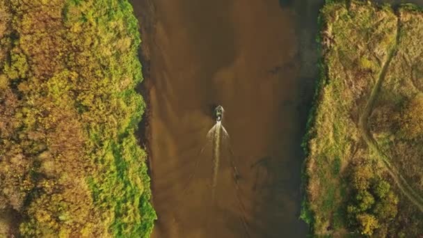 4K Luftaufnahme eines alten Bootes, das in der Herbstlandschaft des Flusses schwimmt. Top-Ansicht der schönen europäischen Natur aus der Höhe. Drohnenflug-Ansicht. Vogelauge erhöhte Ansicht des gelben üppigen Waldes in — Stockvideo