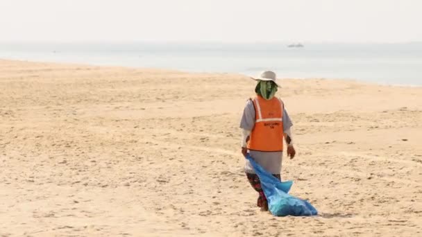 Goa, India - 12 de febrero de 2020: Mujer recogiendo basura en la playa en un día soleado — Vídeos de Stock