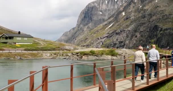 Trollstigen, Andalsnes, Noruega - 19 de junio de 2019: Mucha gente turistas caminando visitando la plataforma cerca del centro de visitantes. Famoso punto de referencia noruego y destino popular. Ruta del Condado de Norwegian 63 — Vídeos de Stock