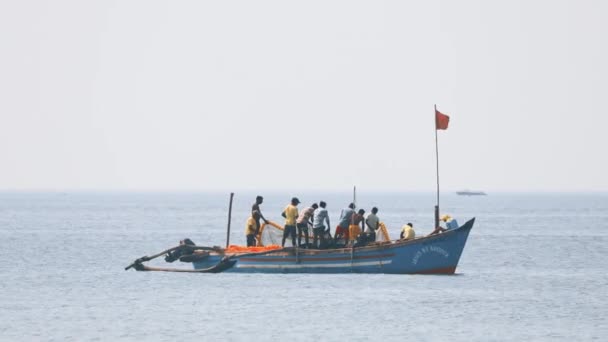 Goa, India - 12 de febrero de 2020: Pescadores en barco tirando de la red de pesca — Vídeos de Stock