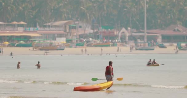 Canacona, Goa, Indien - 16. Februar 2020: Menschen schwimmen im Kajak im Arabischen Meer an einem sonnigen Sommertag. Strand von Palolem — Stockvideo