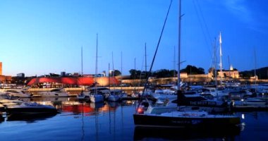 Oslo, Norveç - 24 Haziran 2019: Night View Embankment, Oslo Belediye Binası ve Aker Brygge Bölgesi yakınlarındaki demirli yatlar. Yaz Akşamı. Ünlü ve popüler bir yer. 4K