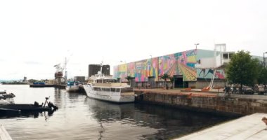 Oslo, Norveç - 24 Haziran 2019: Yaz akşamında Aker Brygge Bölgesi 'nde çok katlı konutların yakınında yürüyen insanlar. Ünlü ve popüler bir yer. 4K
