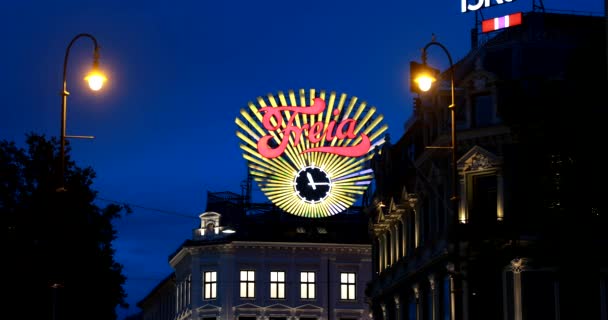 Oslo, Noorwegen - 24 juni 2019: Close Up The Freia Sign In Night. Oud Commercieel Teken voor Noorse chocolade Freia. Noorse chocolade snoep productiebedrijf Freia klok op Egertorget plein. 4K — Stockvideo
