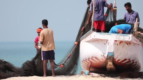 Arossim, Goa, India - 18 лютого 2020: Fishermen Stack Nets On Shore In Boat. повільний, повільний рух. — стокове відео