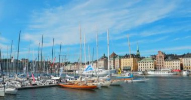 Stockholm, İsveç - 28 Haziran 2019: Güneşli bir günde yelkenli yarışı sırasında birçok demirli yatla Jetty. 4K