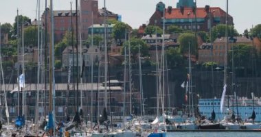 Stockholm, İsveç. Güneşli bir yaz günü yelkenli yelkenli yarışları sırasında bir sürü demirli yatı olan Jetty. 4K