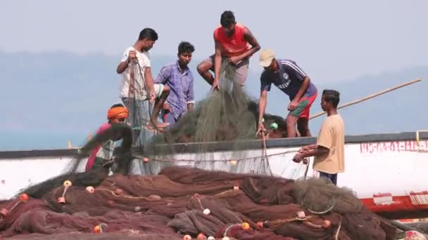 Arossim, Goa, Indien - 18. Februar 2020: Fischer legen Netze im Boot an Land. — Stockvideo