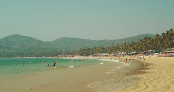Canacona, Goa, Inde - Le 16 février 2020 : Les gens se reposent sur la plage de Palolem lors d'une journée d'été ensoleillée sous le ciel bleu. — Video