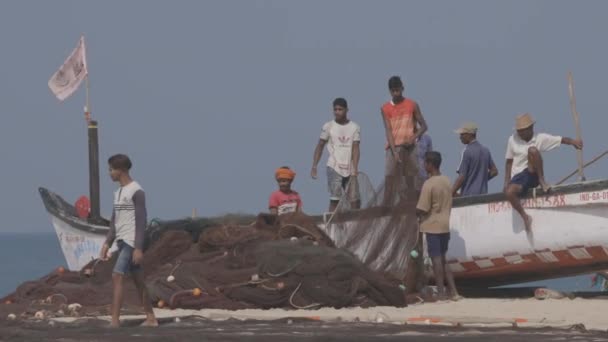 Arossim, Goa, Indie - 18 lutego 2020: Rybacy układający sieci na brzegu. Ludzie na wybrzeżu morskim. 4K, niesklasyfikowany, Canon, C-LOG — Wideo stockowe