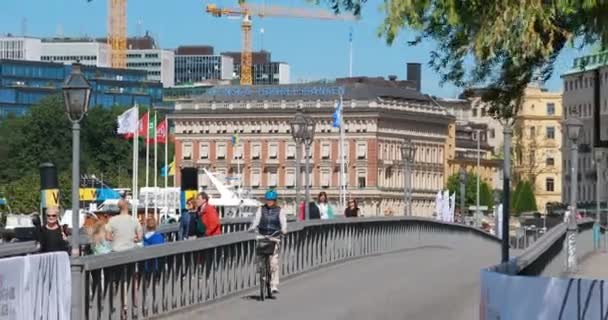 Stockholm, Schweden - 28. Juni 2019: Touristen spazieren auf der berühmten Skeppsholmsbron - Skeppsholm Bridge. Beliebter Ort, Sehenswürdigkeit und Reiseziel in Stockholm, Schweden. 4K — Stockvideo