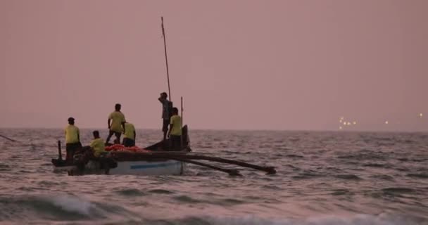 Goa, Indie - 10 lutego 2020: Rybacy w łodzi ciągnący sieć rybacką o zachodzie słońca — Wideo stockowe
