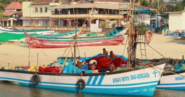 Mapusa, Anjuna, Goa, Inde - Le 19 février 2020 : Des pêcheurs au repos près d'un bateau tiré de la mer. — Video