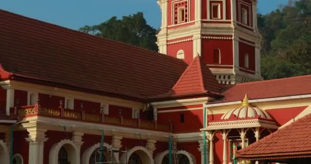 Kavlem, Phonda, Goa, Indie - 20. února 2020: Lidé kráčející poblíž Shree Shantadurga Mandir, chrám Kavlem. Slavný orientační bod a oblíbený cíl. White Lamp Tower. Shantadurga Devi — Stock video