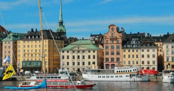 Стокгольм, Швеція - 28 червня 2019: Бачу приємний човник, що плаває біля сцени Знаменитий погляд на набережні в Старому місті. Літнього вечора Гамла Стен. Популярне місце призначення та ЮНЕСКО. 4K — стокове відео