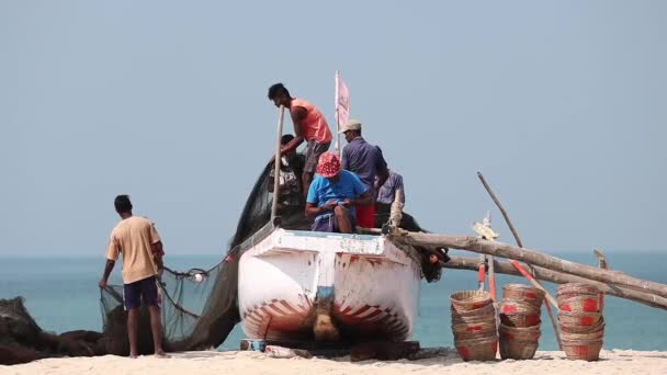Arossim, Goa, Indie - 18 lutego 2020: Rybacy układają sieci na brzegu łodzi. zwolnione tempo, zwolnione tempo. — Wideo stockowe