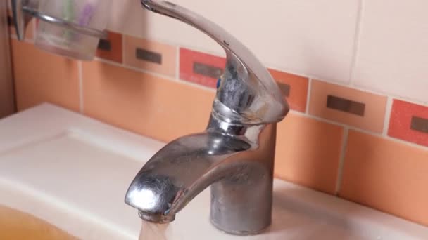 Het roestige water stroomt uit de kraan. Watervervuiling. Wereldwijde omgeving — Stockvideo