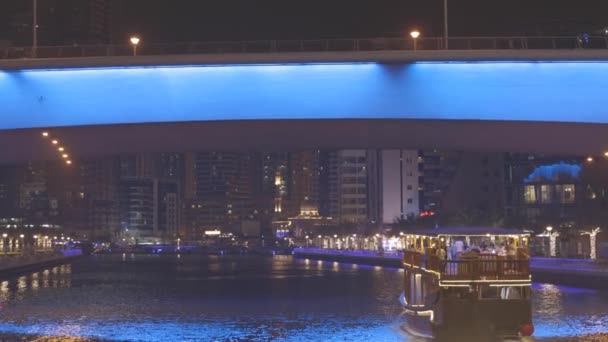 C LOG снимает туристическую лодку, прогулочную лодку, плывущую по Дубайской пристани. Ночная прогулка Dubai Marina - район в Дубае, Объединенные Арабские Эмираты — стоковое видео