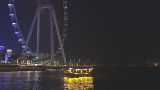 Dubai Marina Port, Zjednoczone Emiraty Arabskie. Łódź turystyczna, łódź wycieczkowa pływająca w pobliżu Ain Dubai to największe na świecie koło widokowe na wyspie Bluewaters w Dubaju, Zjednoczone Emiraty Arabskie Wideo Stockowe