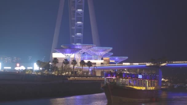 Dubai Marina Port, Verenigde Arabische Emiraten - 19 mei 2021: Toeristische boot, boot varen op Dubai Marina. Night Walk in de buurt van Ain Dubai is 's werelds grootste observatie wiel gelegen op Rechtenvrije Stockvideo