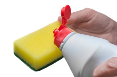 Bir elinde bulaşık deterjanı, diğer elinde de beyaz arka planda izole edilmiş bir sünger var.