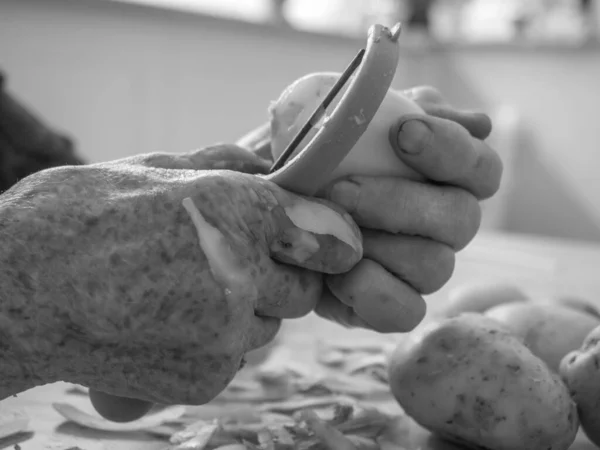Old Hands Peeling Potatoes — Stockfoto
