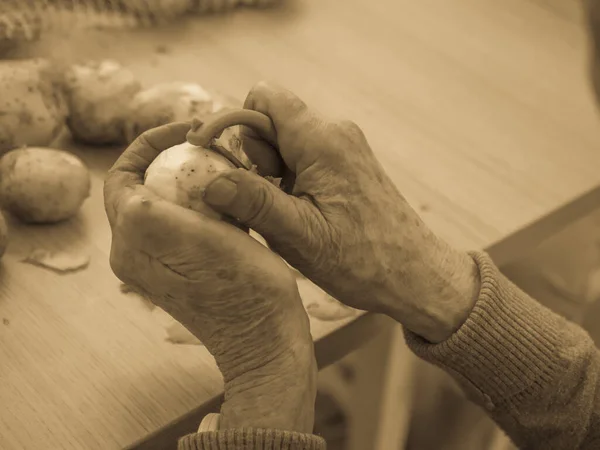 Old Hands Peeling Potatoes — Stock Photo, Image