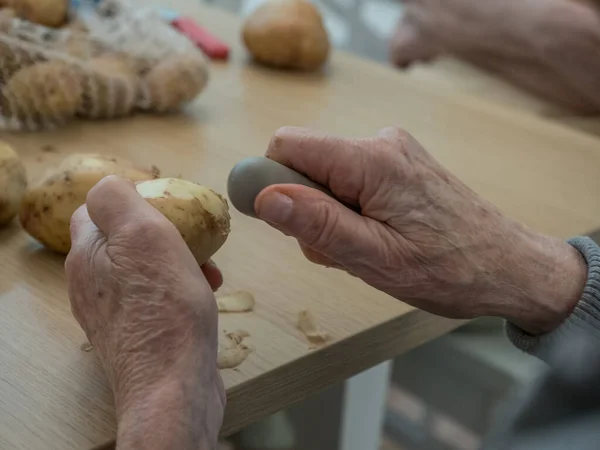 Old Hands Peeling Potatoes — Stock Photo, Image