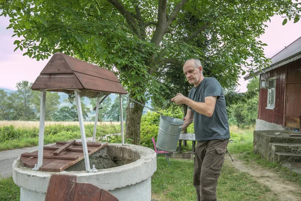 Man Taking Water Old Stone Water Well Windlass Crank Polish — Stockfoto