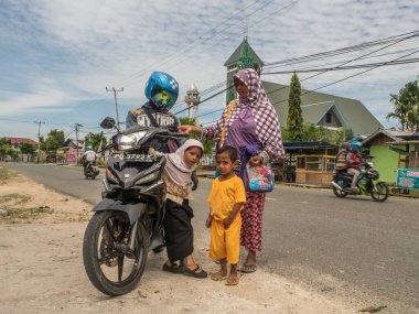 Kaimana, Endonezya - 31 Ocak 2018: Batı Papua 'daki küçük bir köyde motosikletli Endonezyalı aile