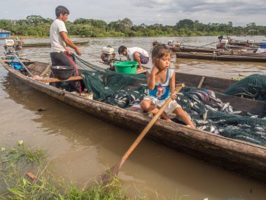Amazon nehri, Peru 11 Aralık 2017 küçük Perulu kız balıklarla dolu ahşap bir teknede oturuyor..