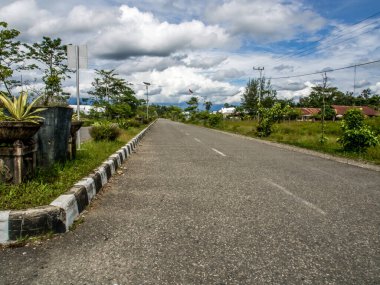 Dekai, Endonezya - 12 Ocak 2015: Siyah, asfalt yol ufka kadar uzanıyor. Batı Papua.